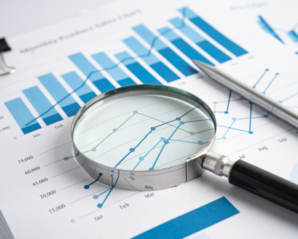 Magnifying glass on a paper with graphs depicting the importance of providing clear and transparent information to improve the client journey