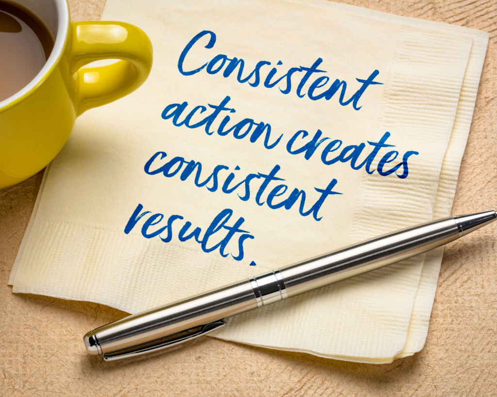 Photo of 'Consistent action creates consistent results' written on a napkin with a pen and a yellow mug of coffee depicting the importance of consistency in your client journey